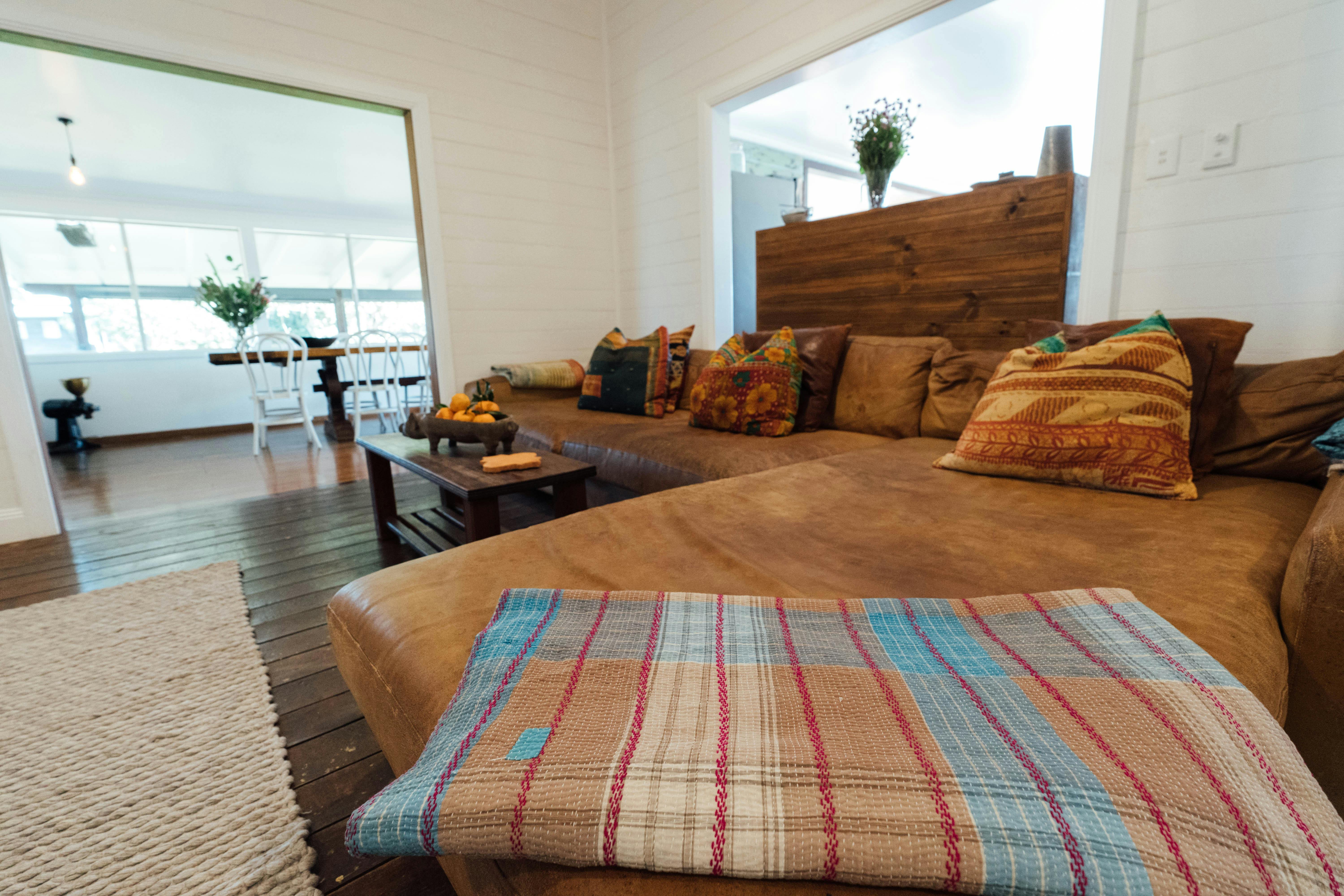 Large leather lounge with colourful blanket with plenty of room for the whole family