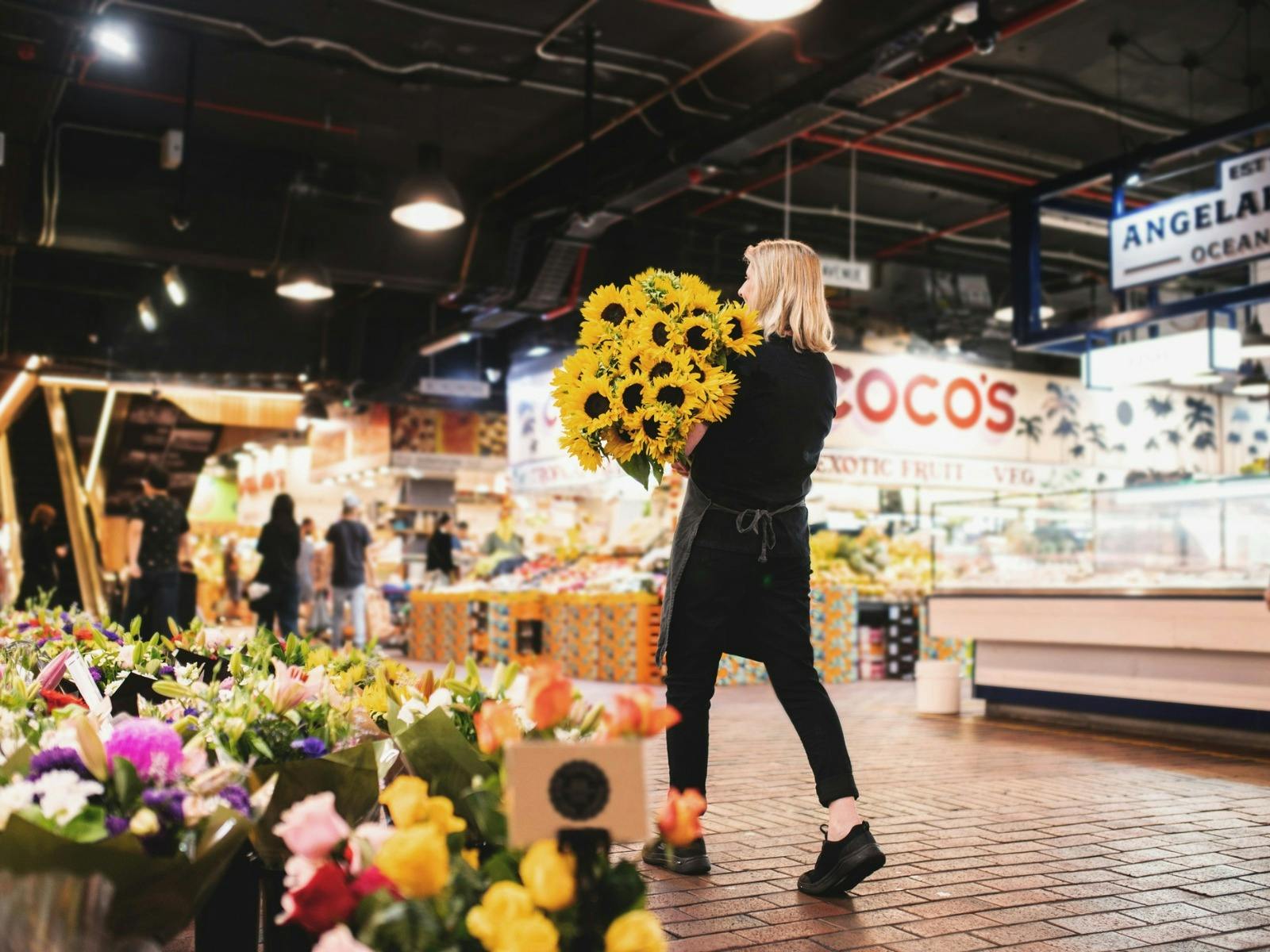 Girl holding flowers walking away from camera