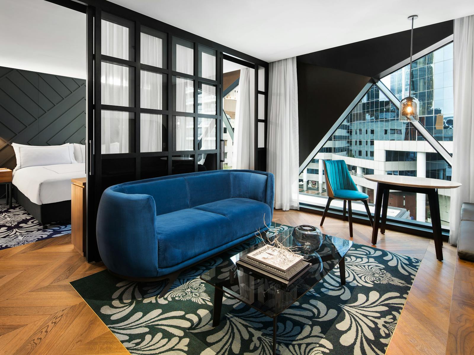 The suite is designed in rejuvenating blues and greens,  hardwood parquetry floor and stone bathroom