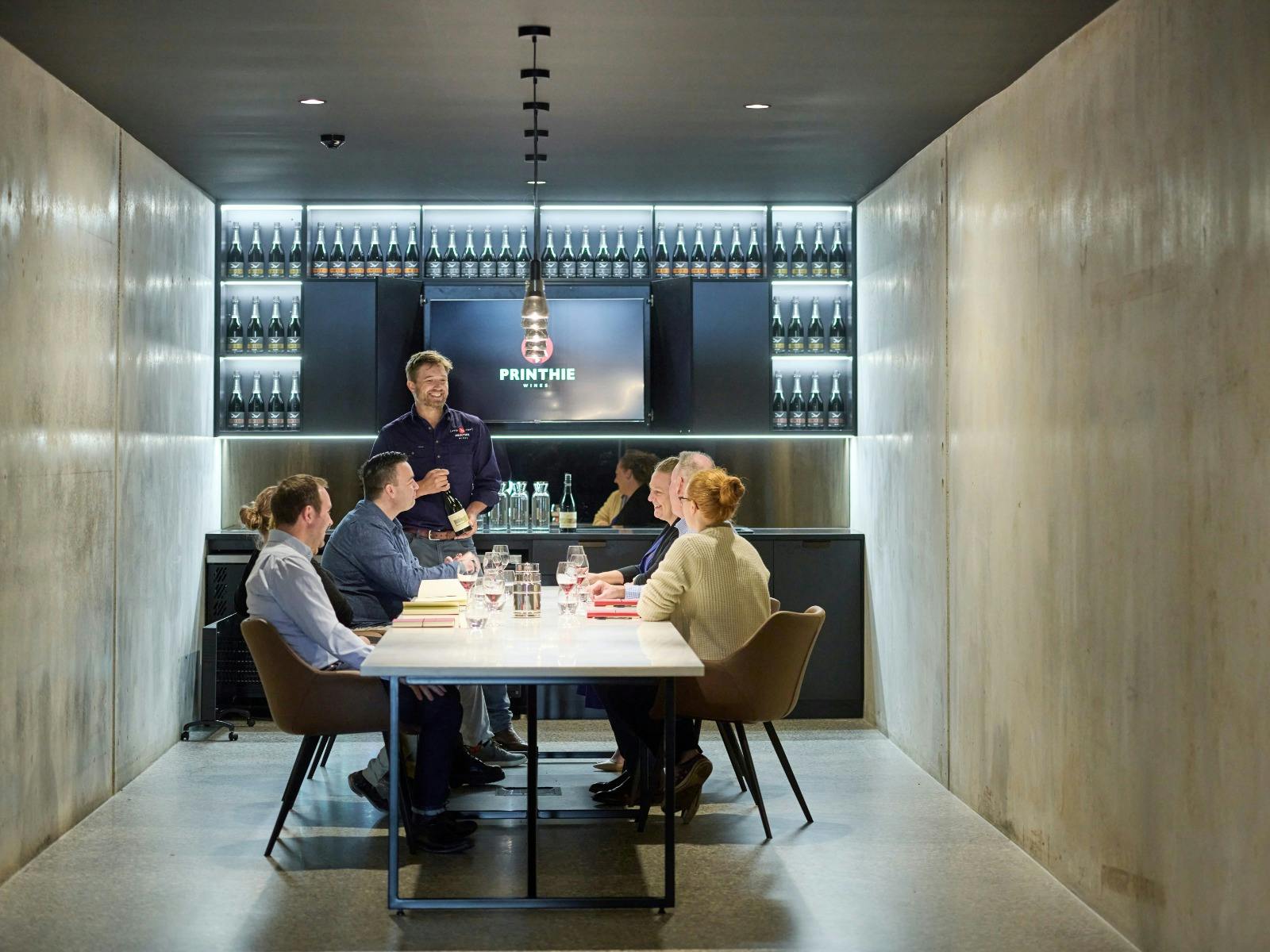 Group of people enjoying a private wine tasting in the private cellar