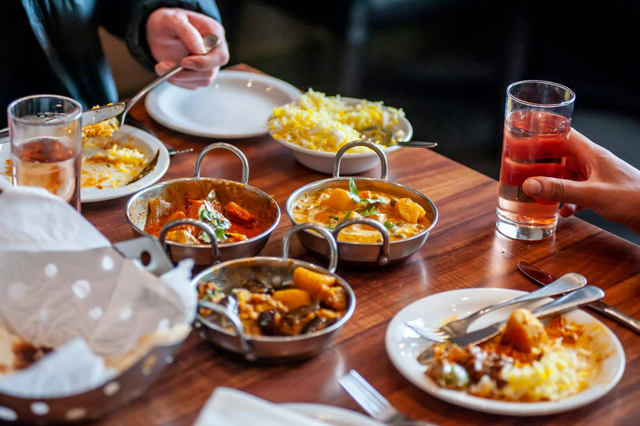 Dining table with a variety of food dishes in front of diners