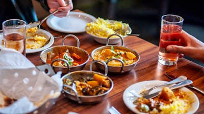 Dining table with a variety of food dishes in front of diners