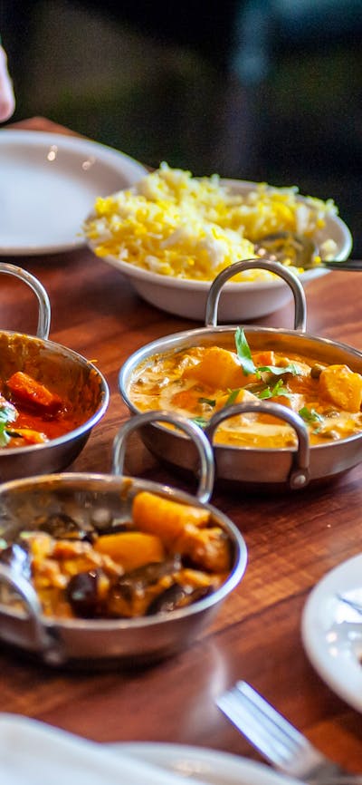 Dining table with a variety of food dishes in front of diners