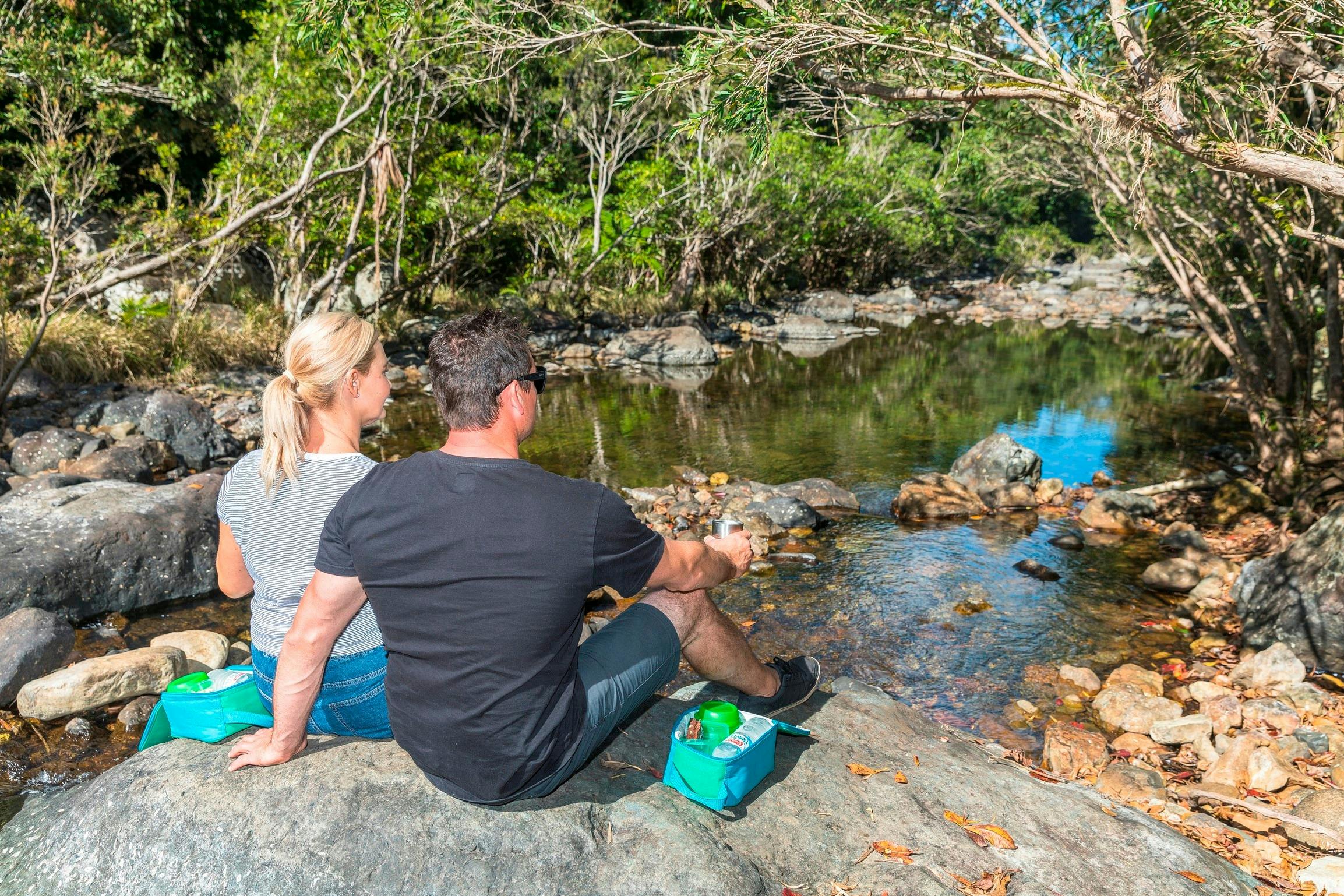 Couple relaxing at Impulse Creek, Conway National Park, Airlie Beach, Whitsunday Segway Tours