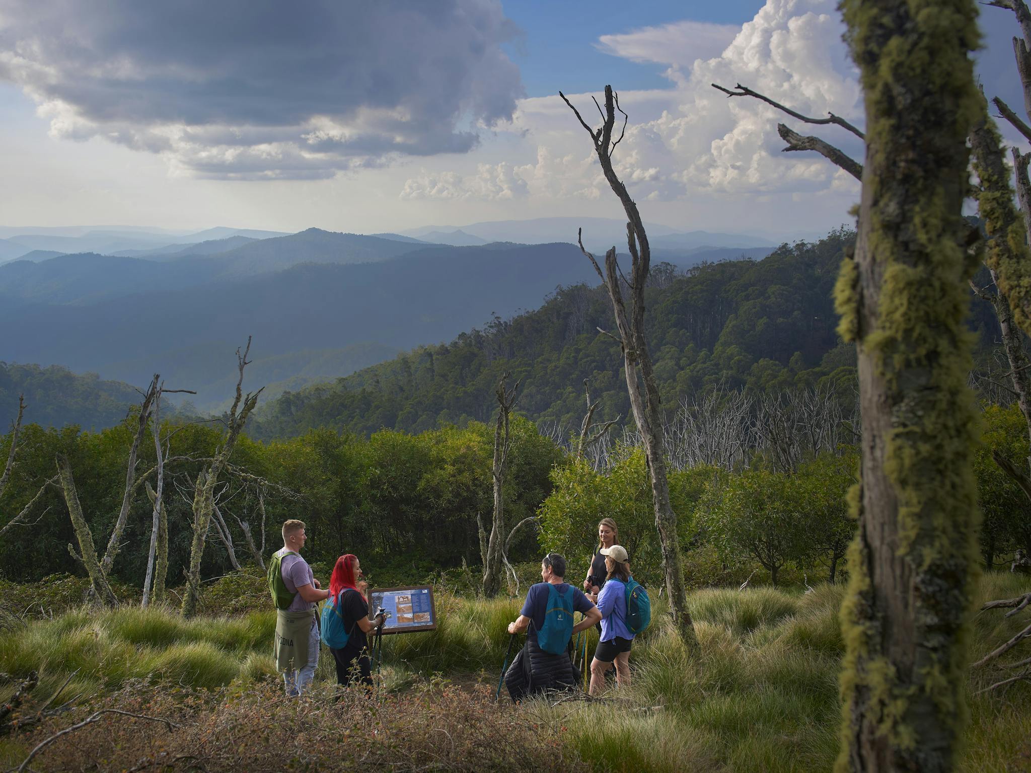 A group of hikers stopping to enjoy views across the mountains.