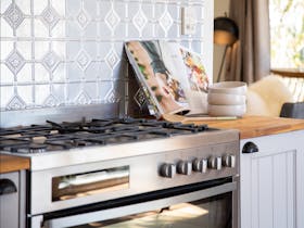Large gas cooker with a magazine and bowls on the bench beside