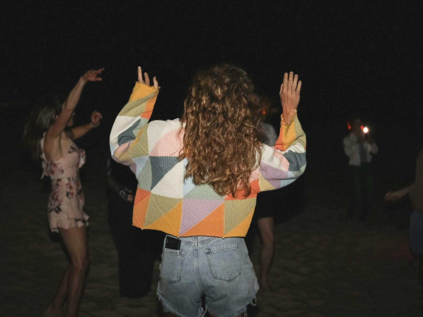 100's of people dancing on the beach atSilent Disco Under the Stars at SWELL Sculpture Festival 2024