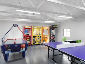 A games room with ping pong table and other electronic games machines