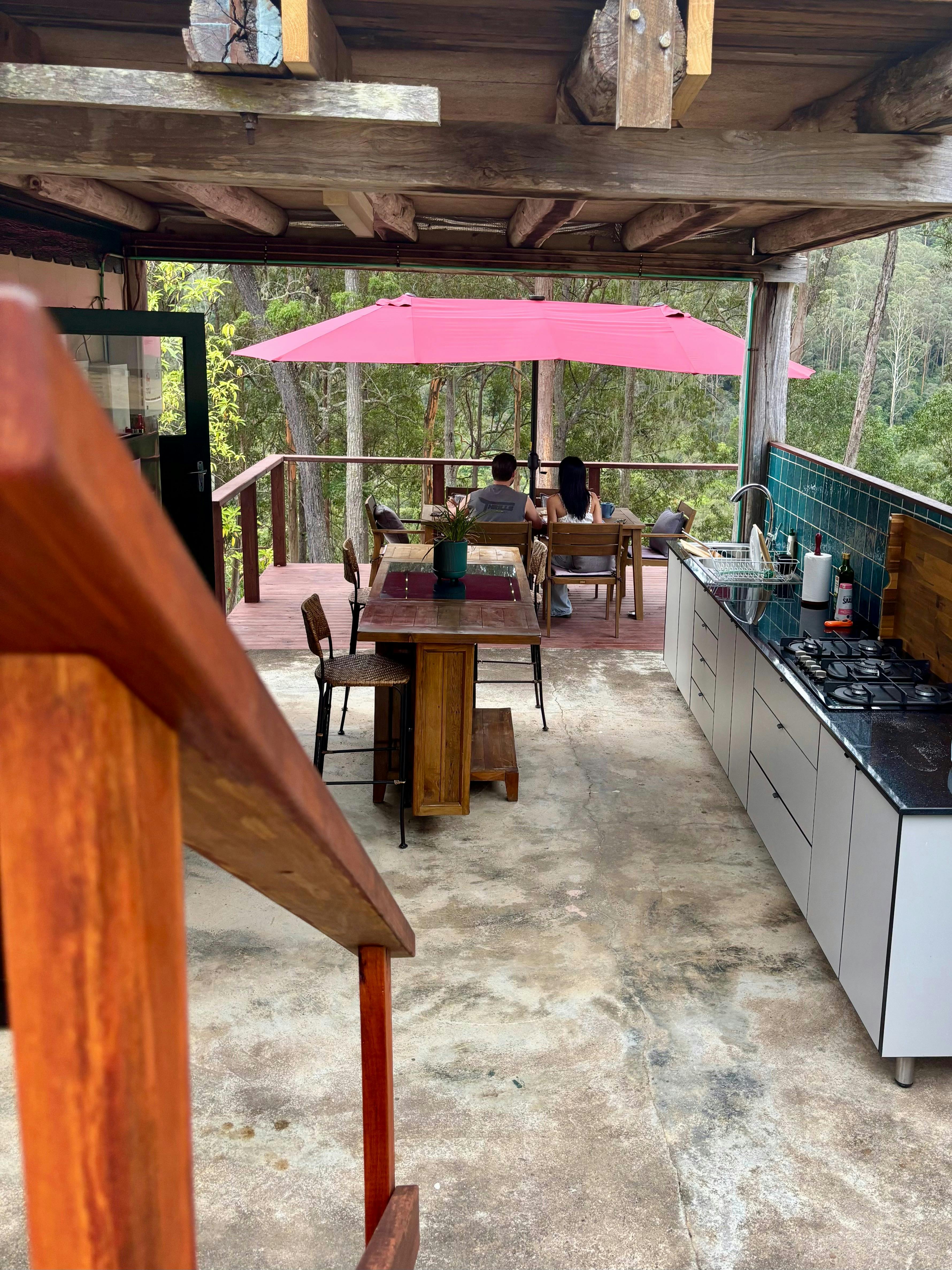 Couple enjoying the view over the property from the deck with an outdoor kitchen