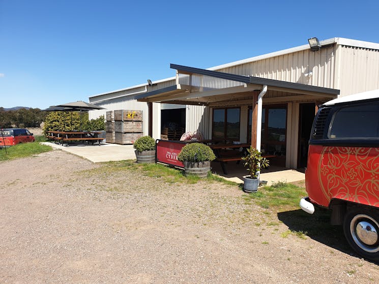 The outdoor tasting area at Small Acres Cyder with covered seating areas, a deck with picnic tables.