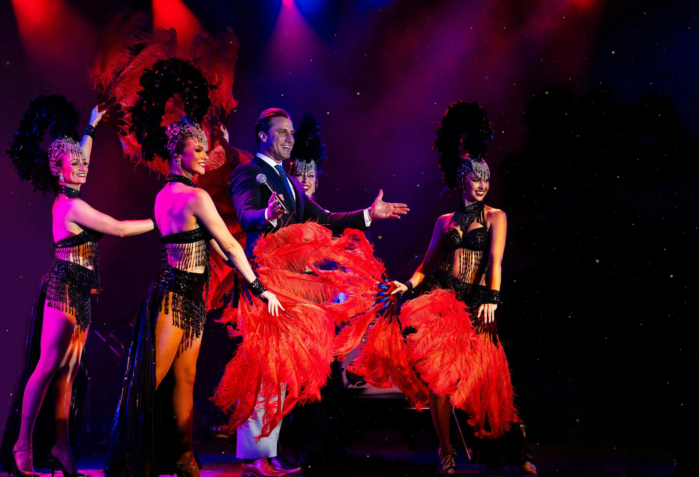 PJ Lane posing with dancers on stage.