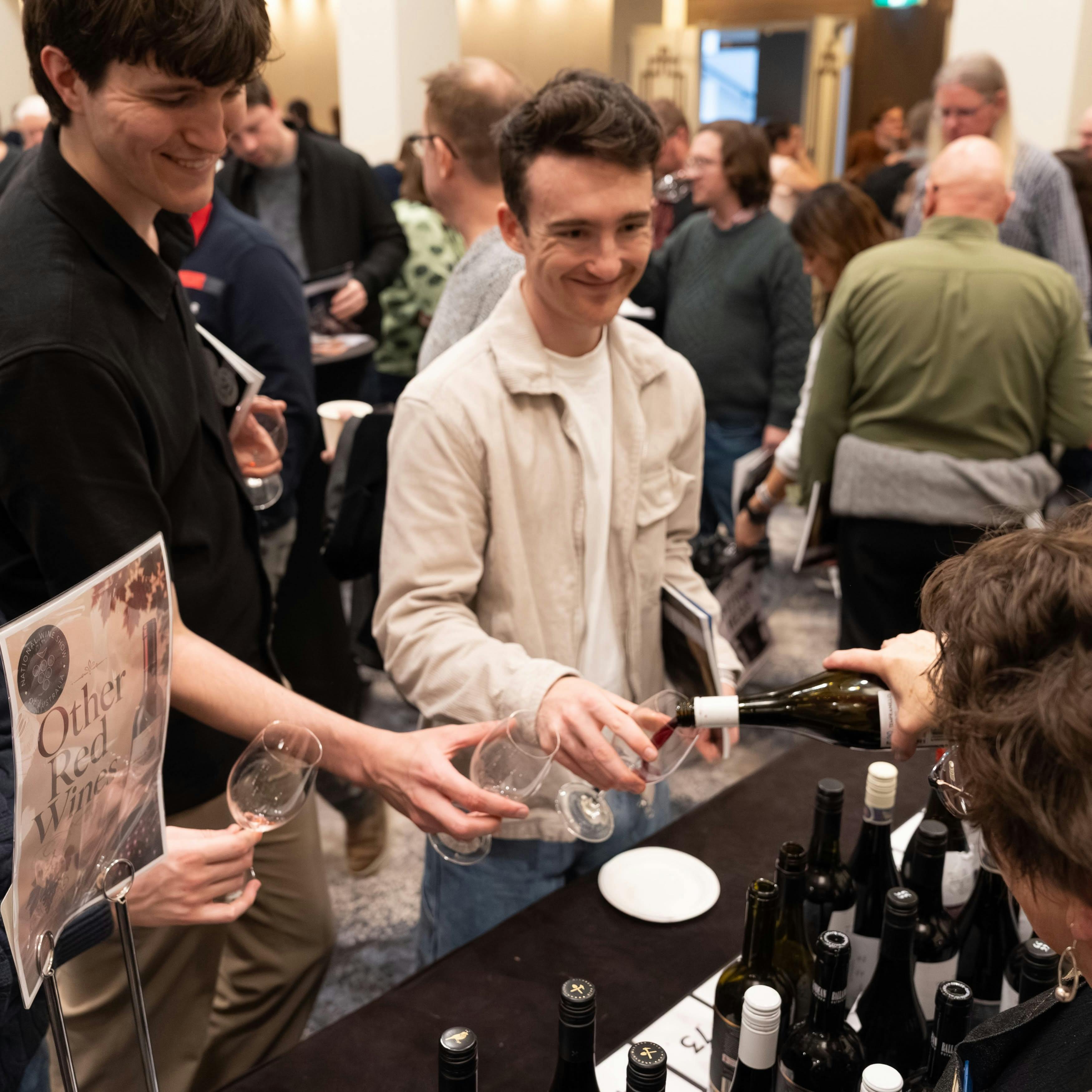 Young men having wine poured into their glass