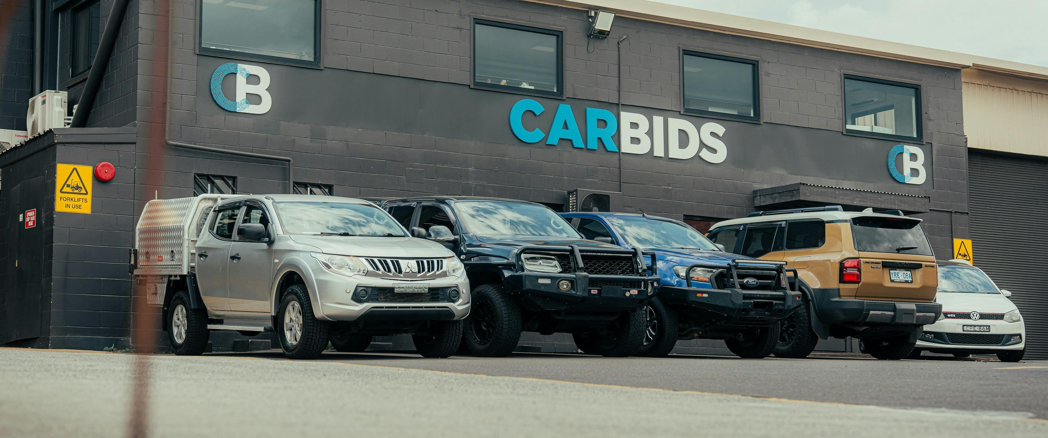 Outside shot of the CARBIDS building showing the signage and a selection of cars