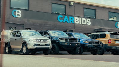 Outside shot of the CARBIDS building showing the signage and a selection of cars