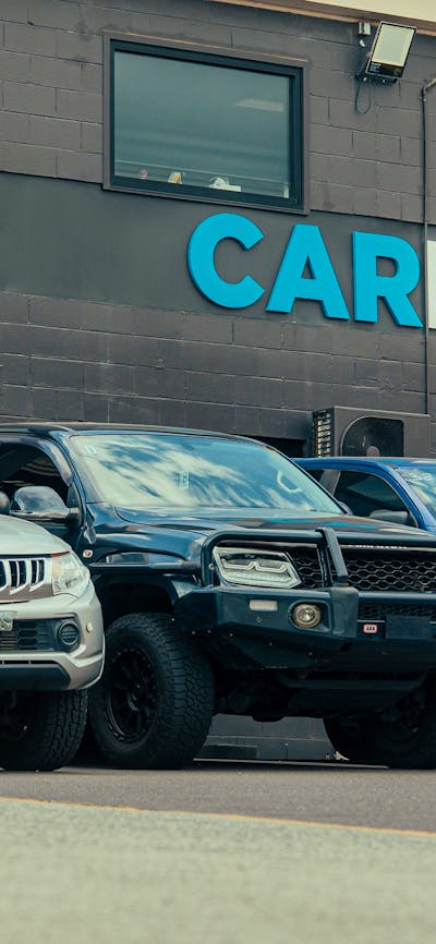 Outside shot of the CARBIDS building showing the signage and a selection of cars