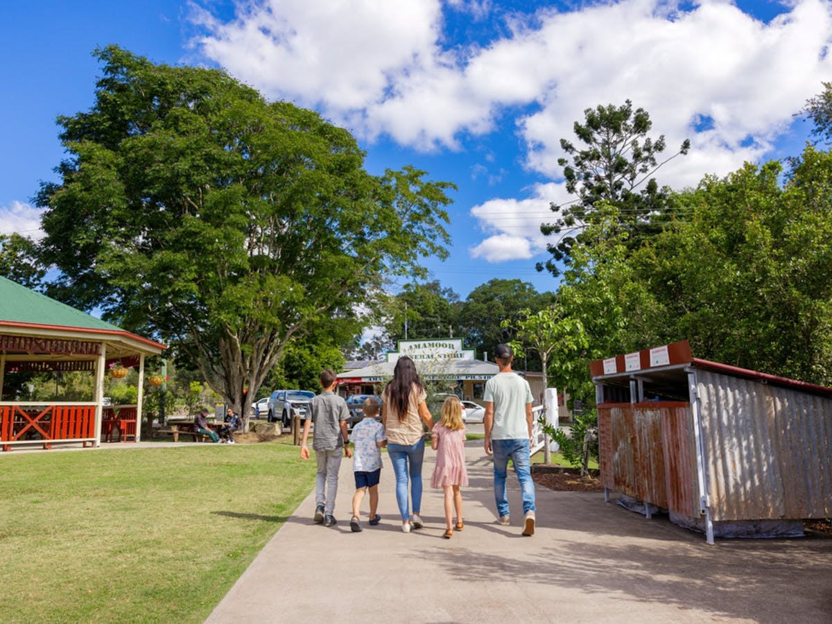 Family walking through the park towards the Amamoor general store