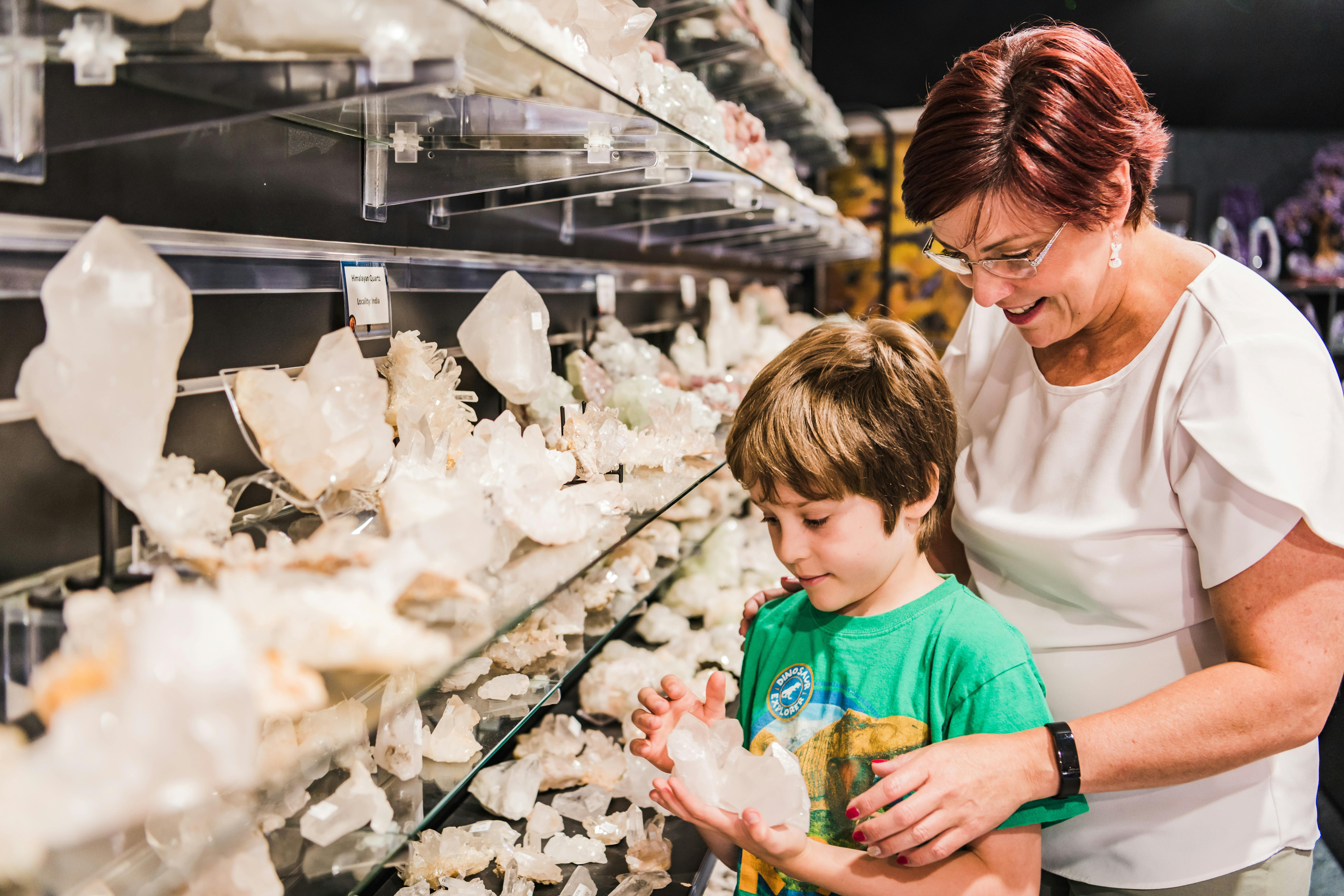 Little boy looks at clear quartz with Auntie