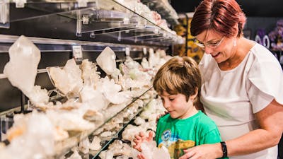 Little boy looks at clear quartz with Auntie