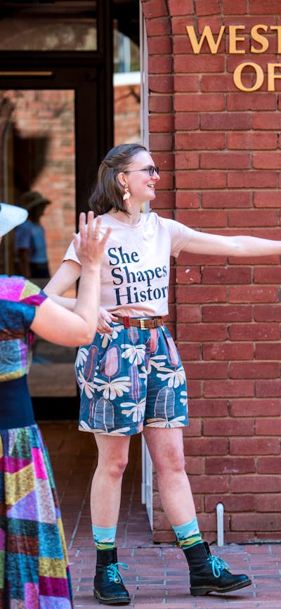 She Shapes History tour guide presenting to the group of engaged guests