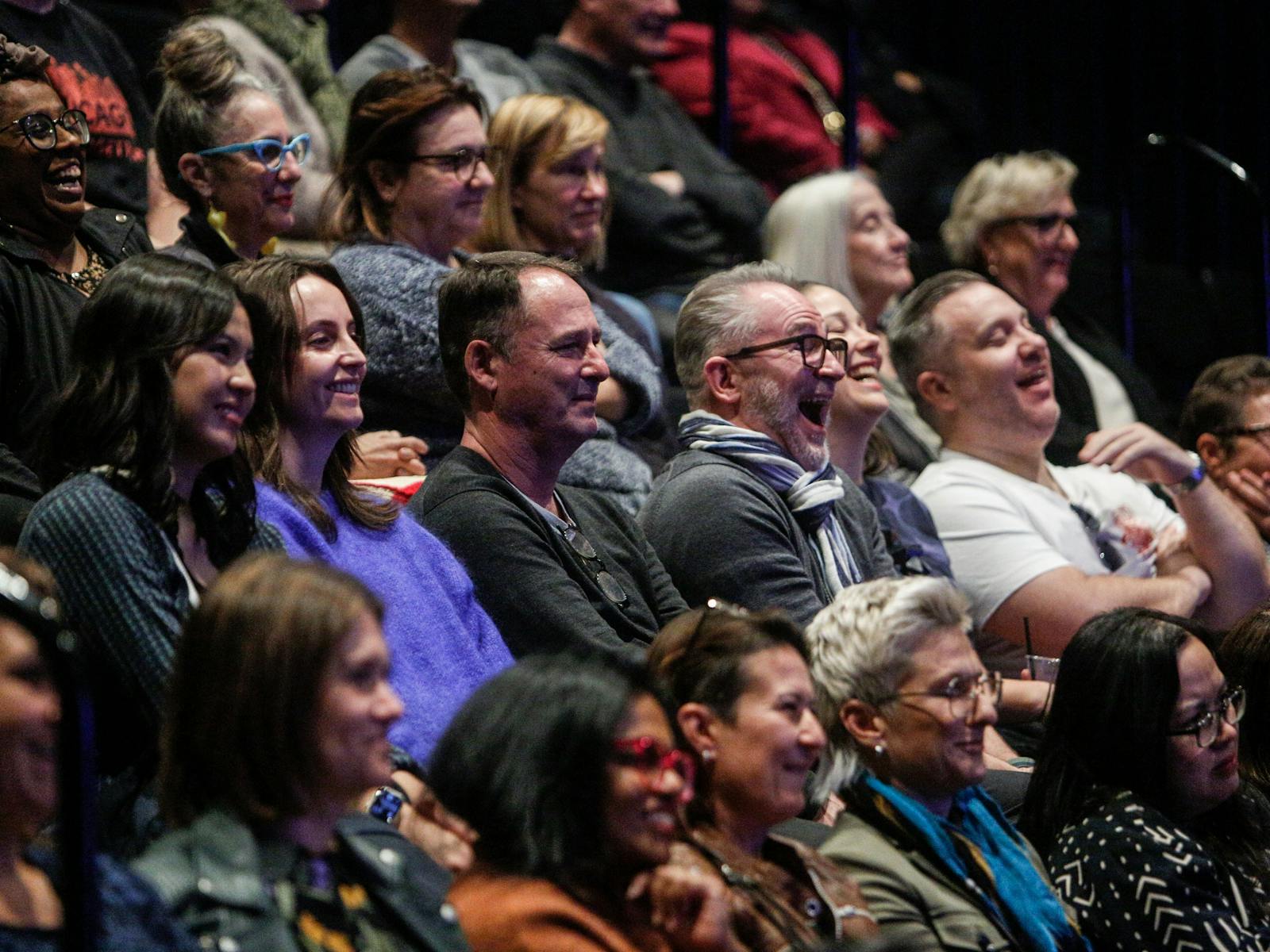Audience members laughing