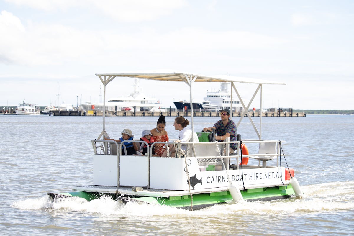 A family exploring the Trinity Inlet on a hired pontoon boat in Tropical North Queensland