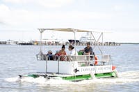 A family exploring the Trinity Inlet on a hired pontoon boat in Tropical North Queensland