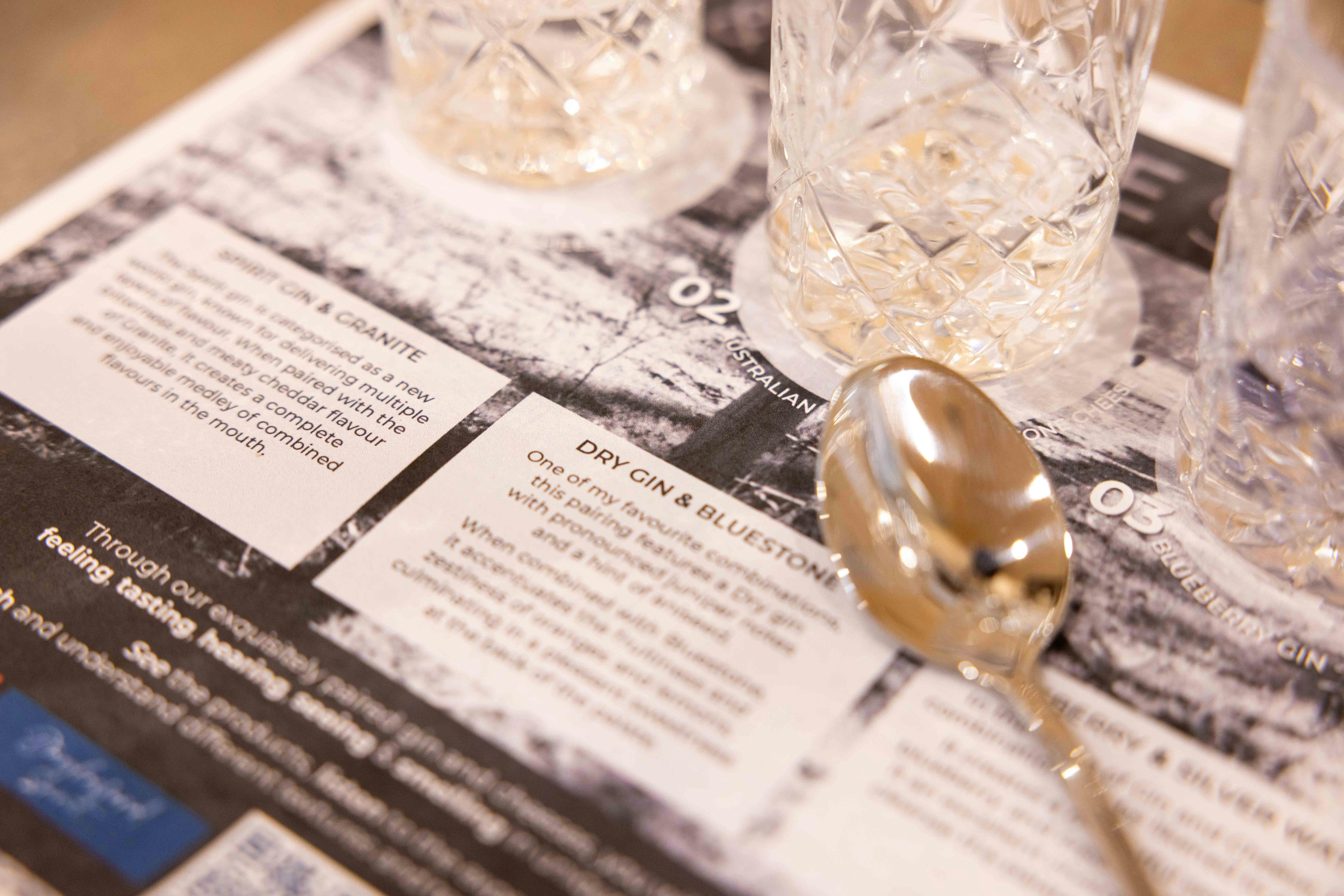 A printed menu, gin classes and spoon ready for the guests' tasting session