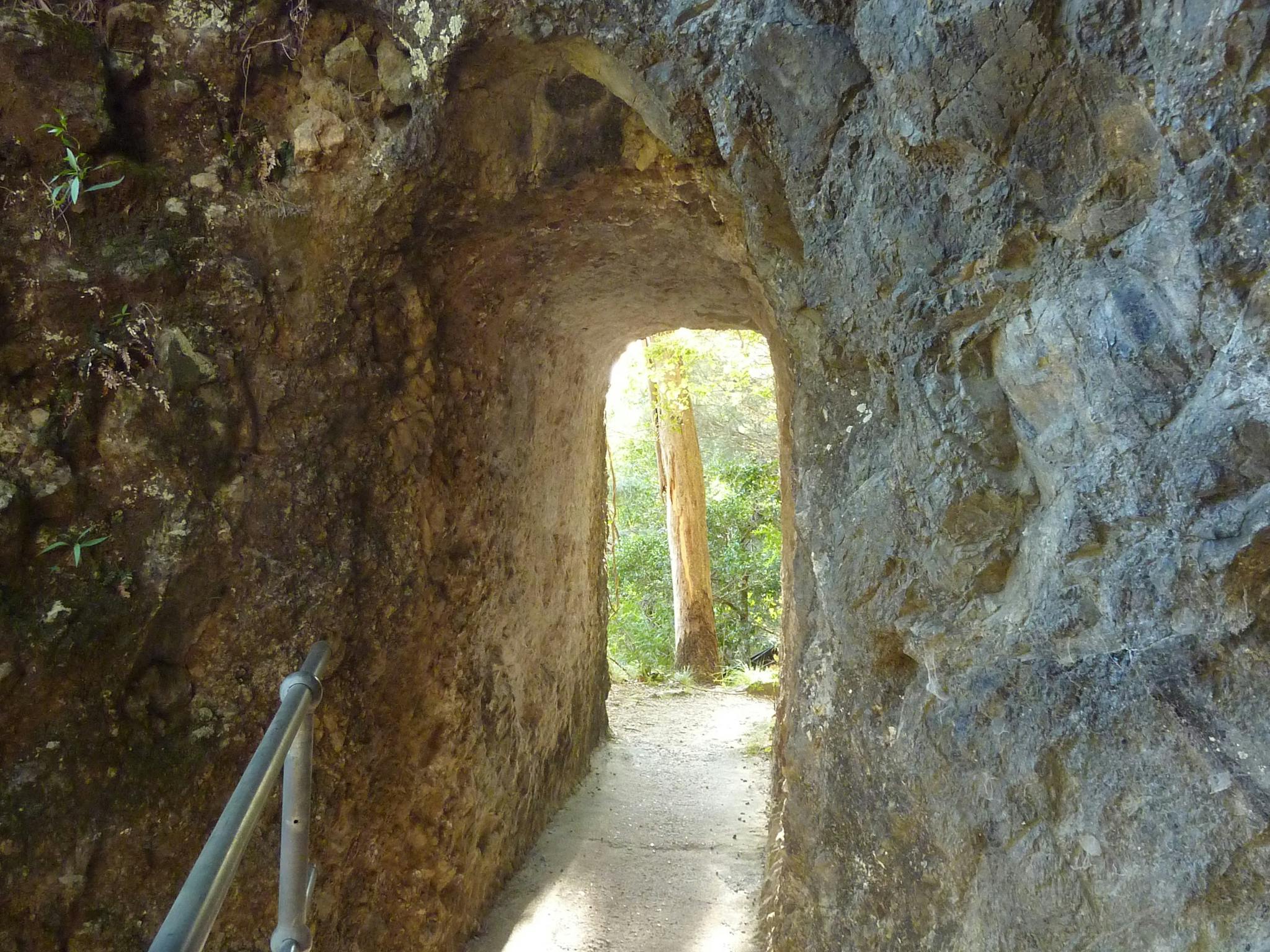 Artificial cave through rock with concrete floor and hand rail. Artificial cave through rock with concrete floor and hand rail.
