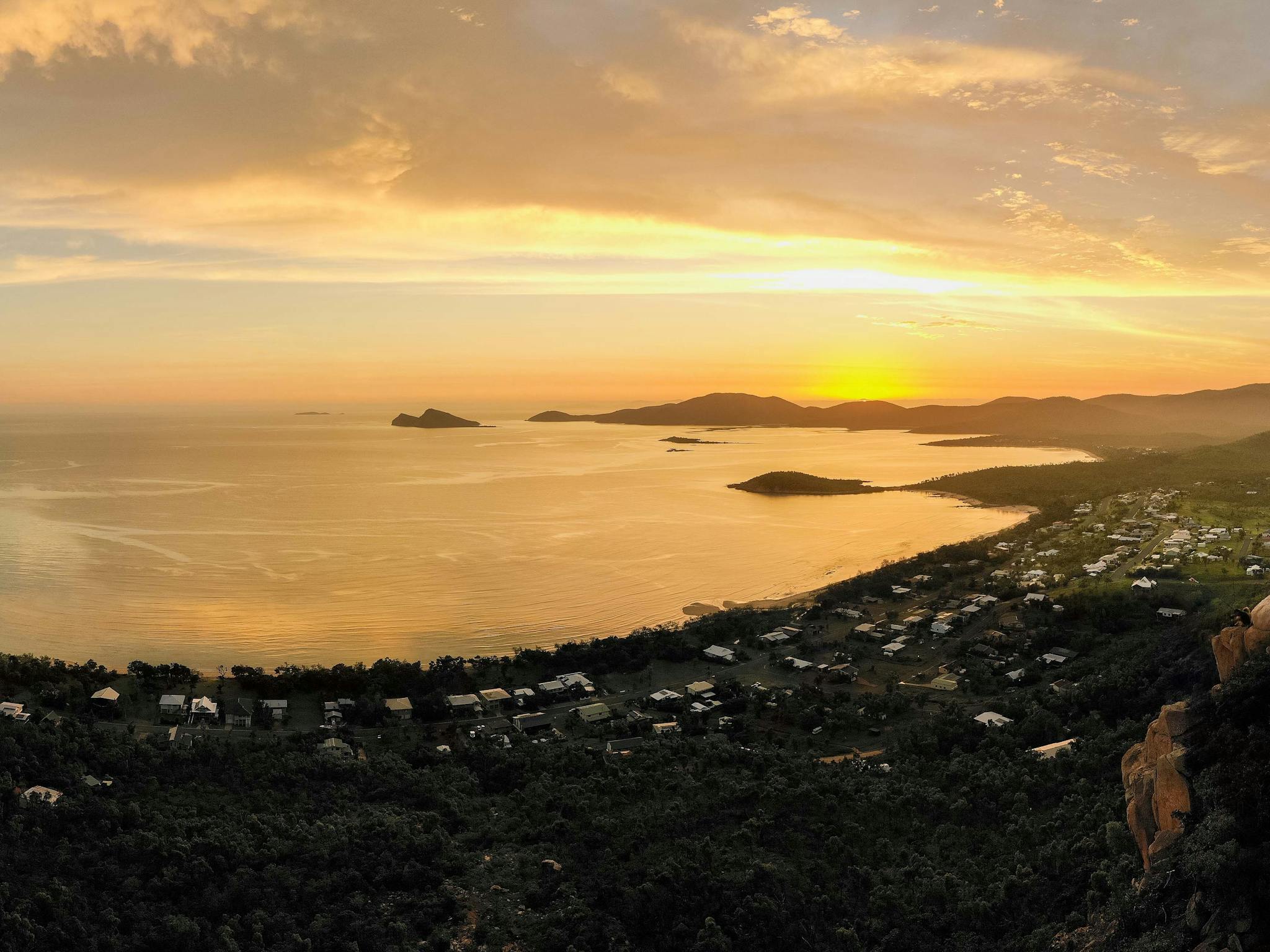 Aerial view from a hilltop at sunset overlooking homes and water at Hydeaway Bay
