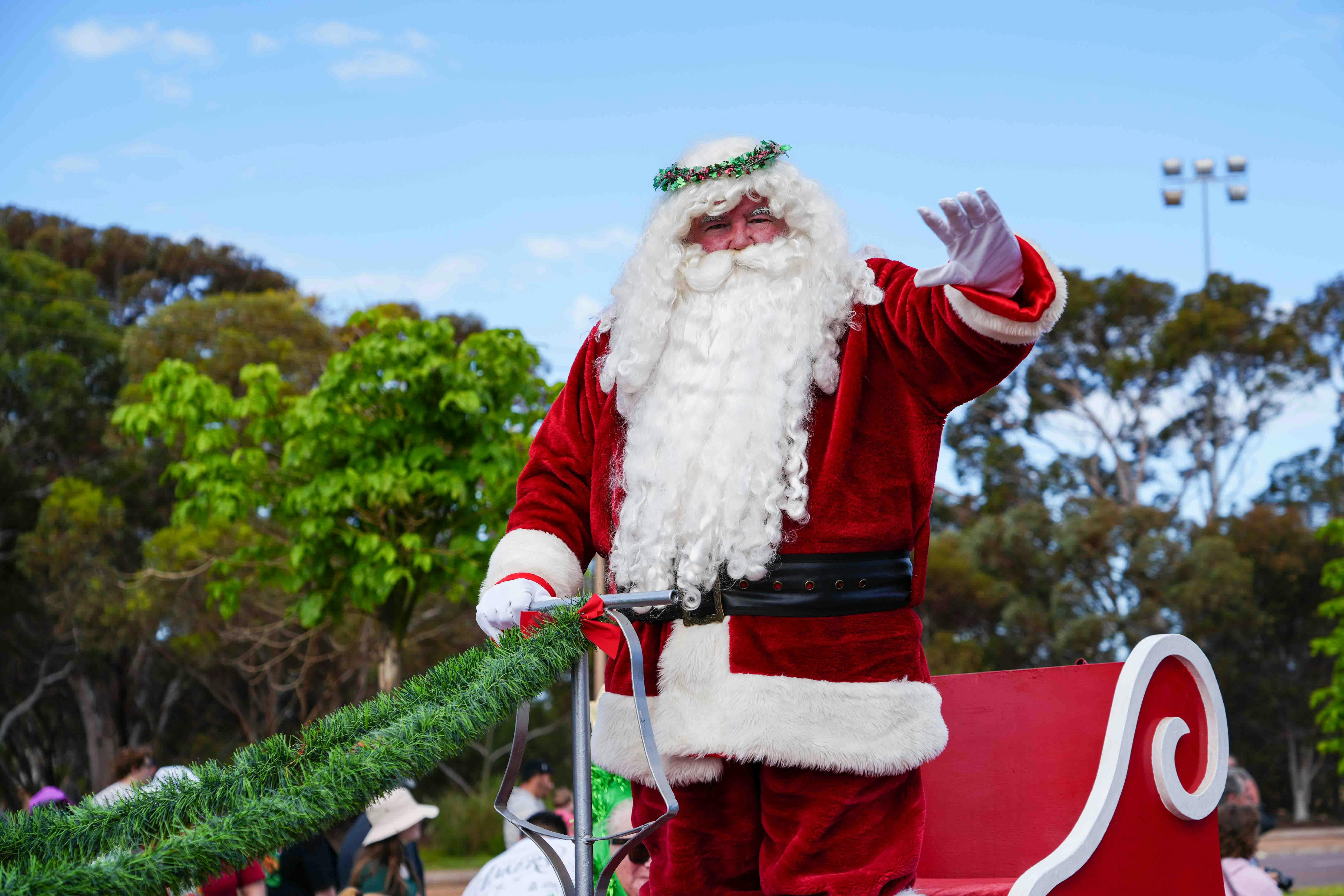 Father Chrismas standing up on a  sleigh waving