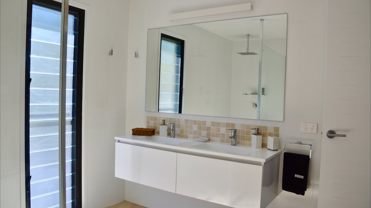 Main bathroom features double basin, bath and rain head shower