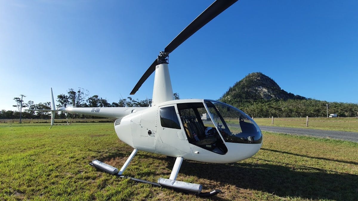 Photo of helicopter in front of mountain