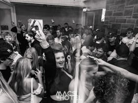 Crowd dancing and socialising inside Macs Hotel nightclub area