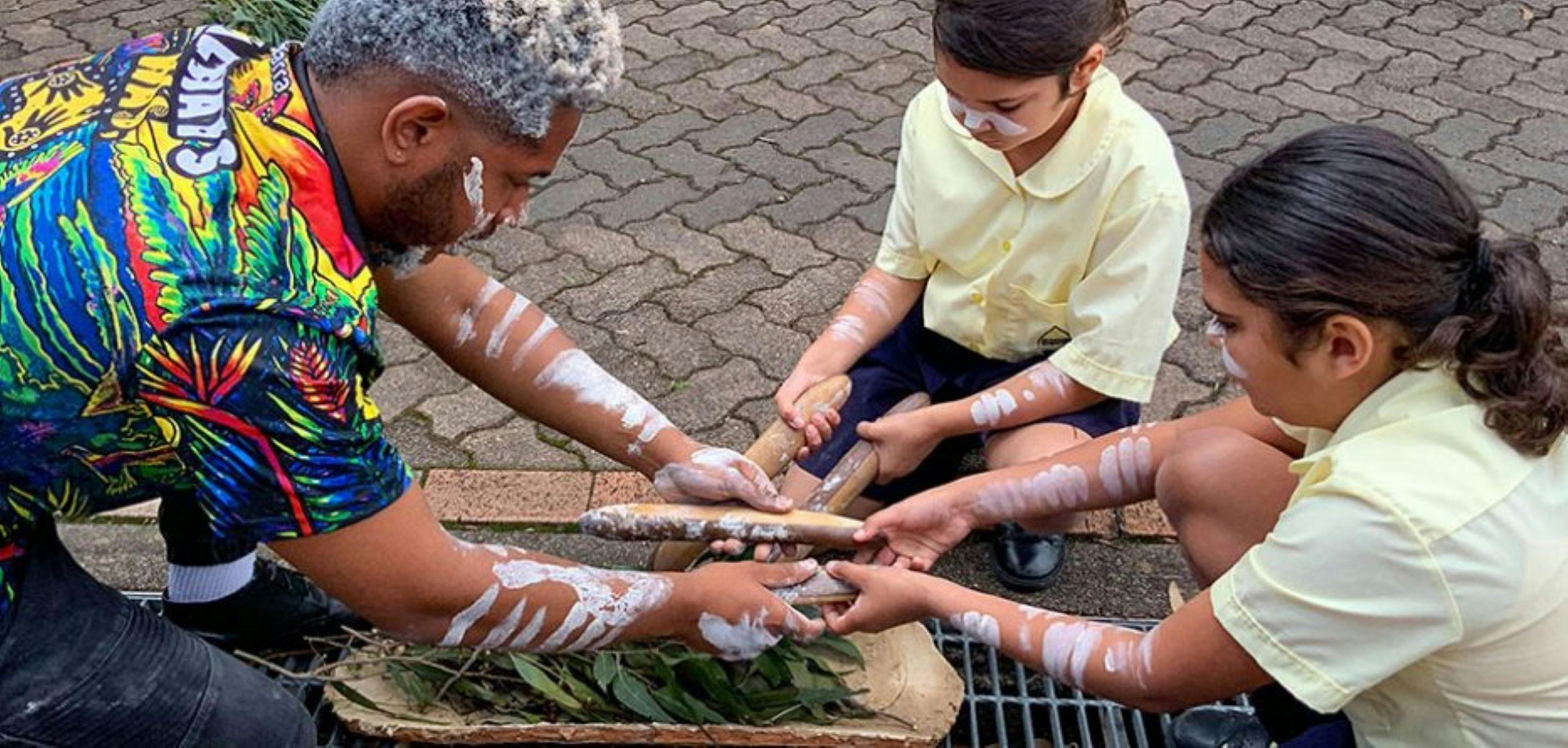 Image of Man and Children lighting a fire/smoking ceremony