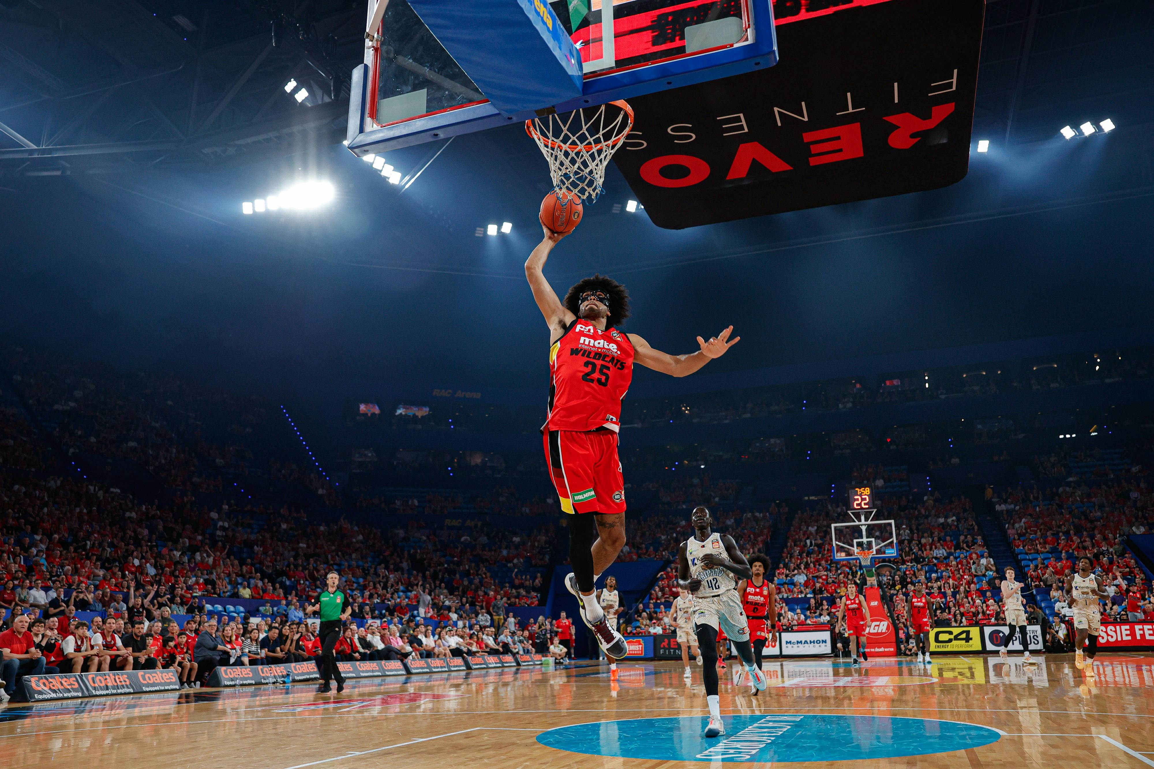 Perth Wildcats player Keanu Pinder slam dunks the ball into the hoop on the court at RAC Arena