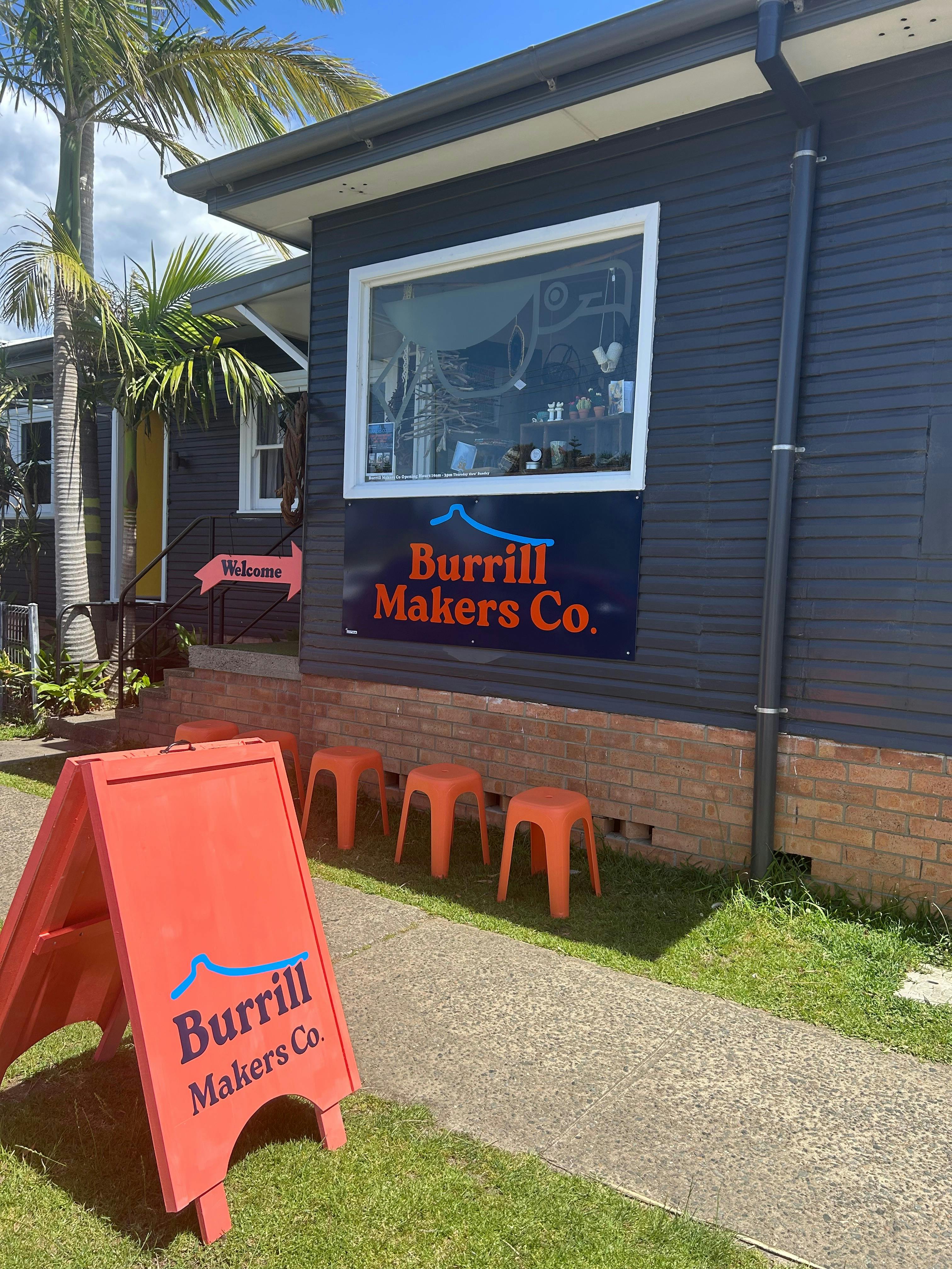 The exterior of Burrill Makers Co from McDonald Parade with orange and blue signage.