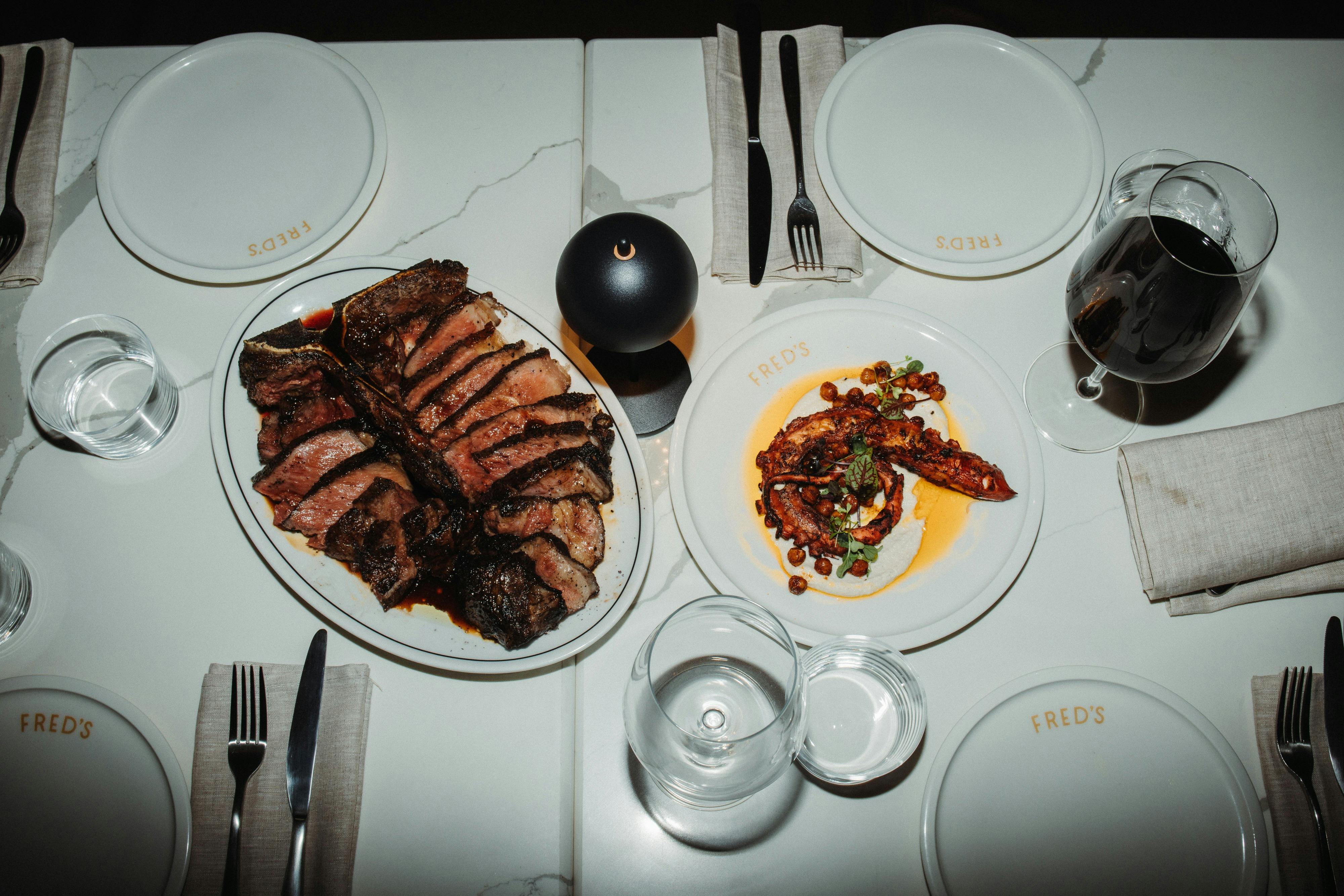 A Bistecca on a plate and octopus on a plate and dining table set
