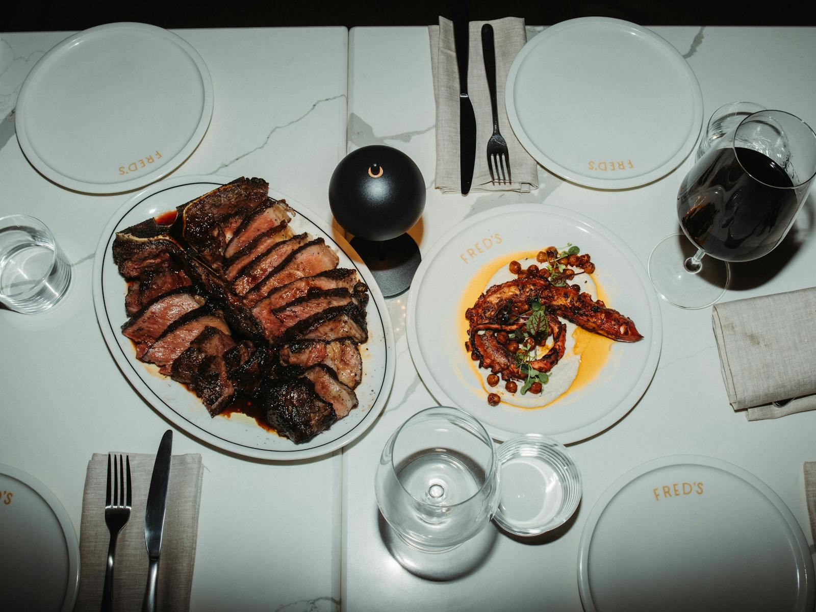 A Bistecca on a plate and octopus on a plate and dining table set