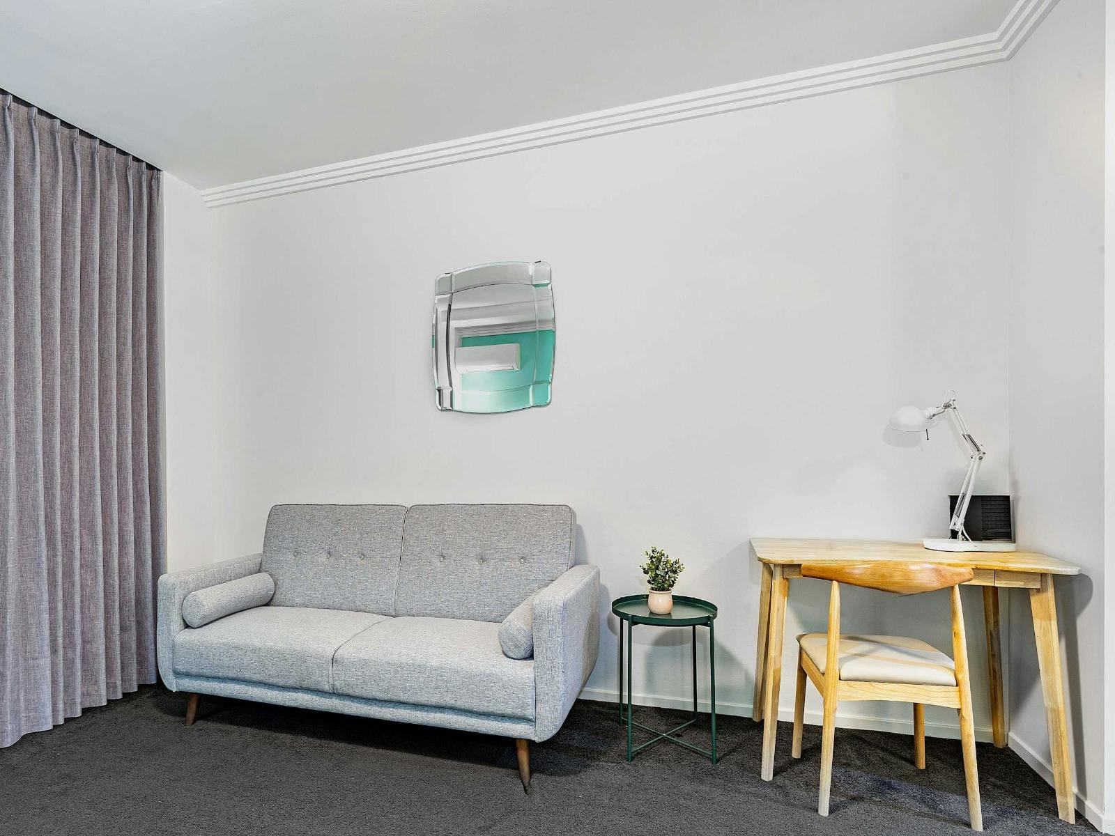 Additional angle of the sofa bed with work desk and wall décor.