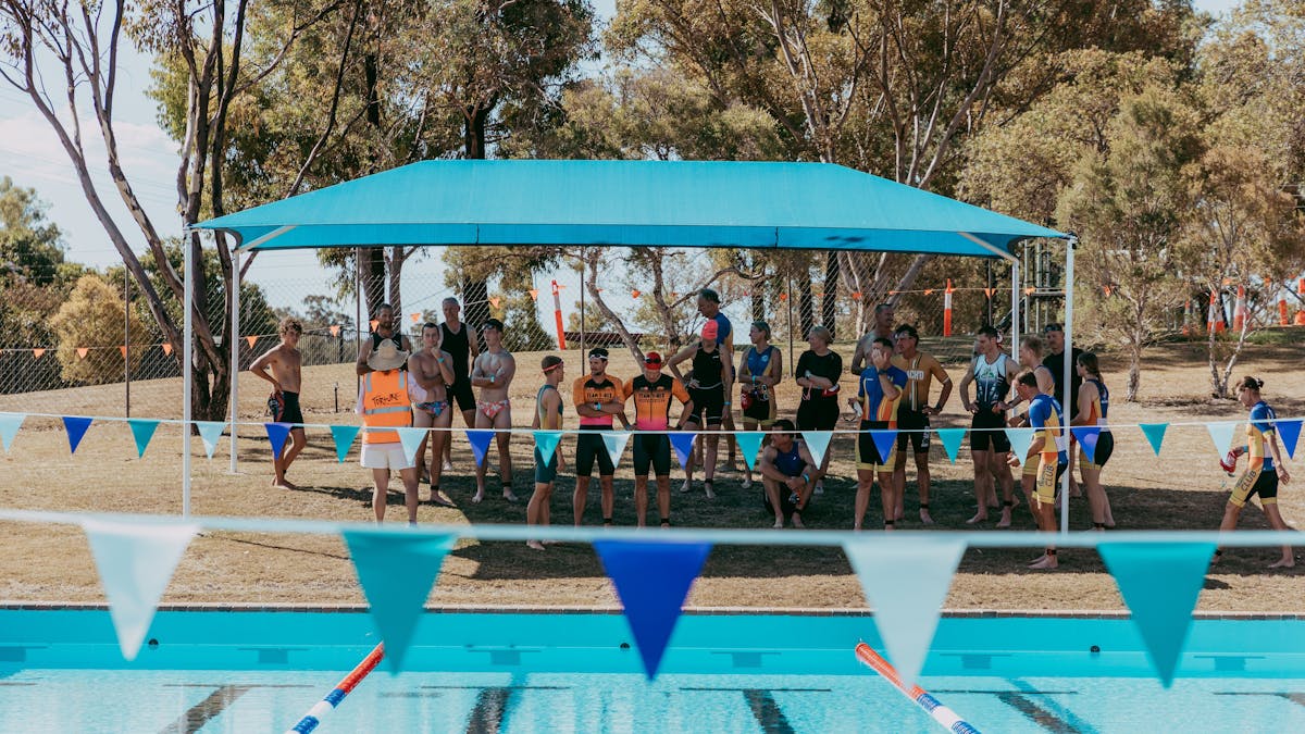 People gathered under the shade cloth at the Texas Swimming Pool