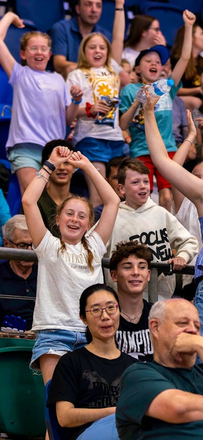 Crowd cheering and jumping at a UC Capitals game.