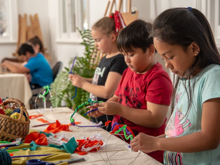 children work on creative projects at table