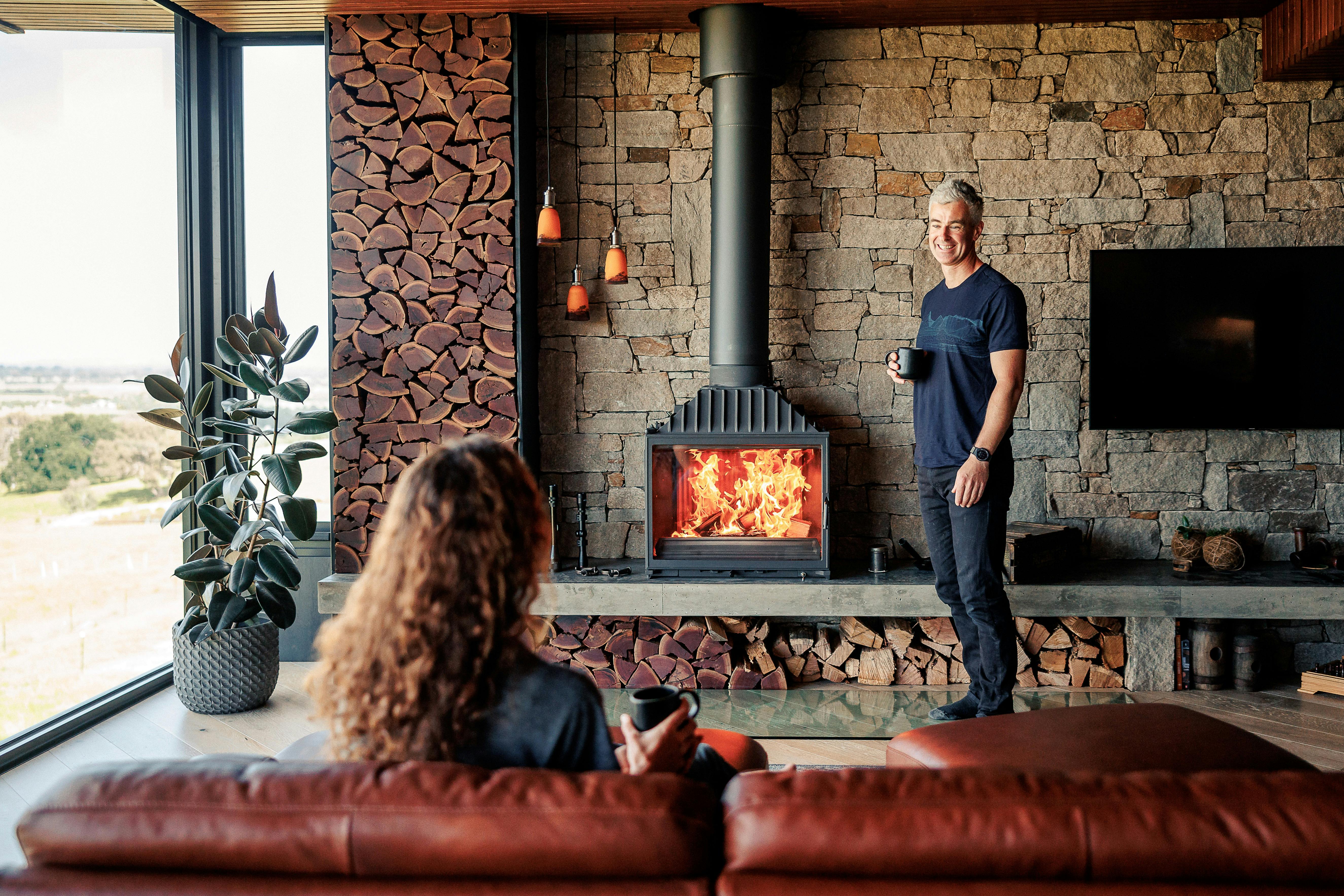 Couple enjoying the warmth of the fireplace at BullerRoo Luxury Farmstay
