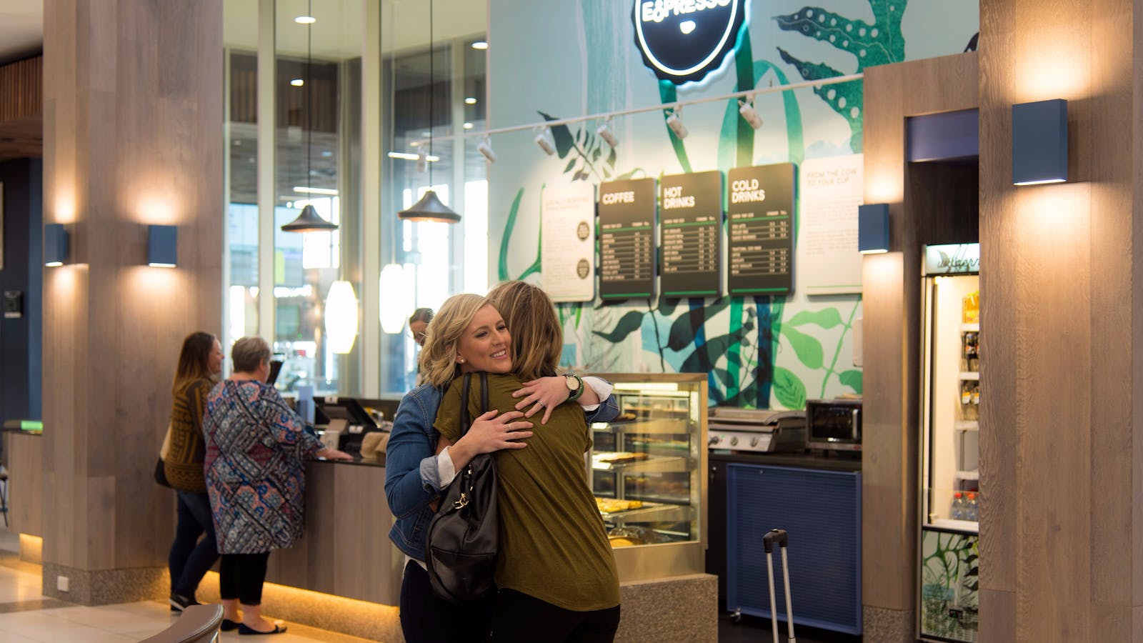 Passengers greet each other in front of Wilderness Espresso Cafe at Launceston Airport