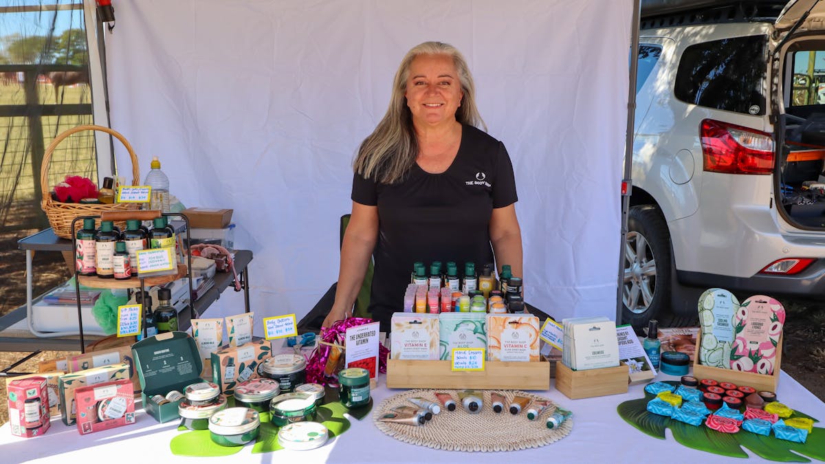 Lady standing behind a table with homemade goods Lady standing behind a table with homemade goods