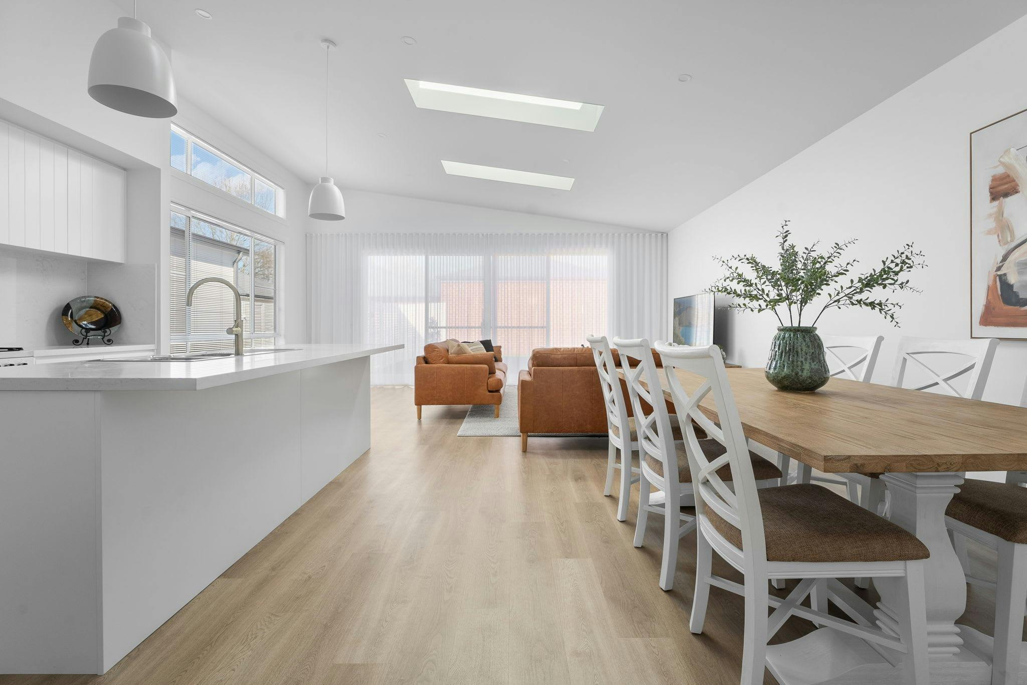 Large open living are with large modern kitchen, large dining table for 8 and 2 sofas for guests