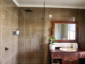 Master bathroom with a walk-in shower, vanity and wall mirror.