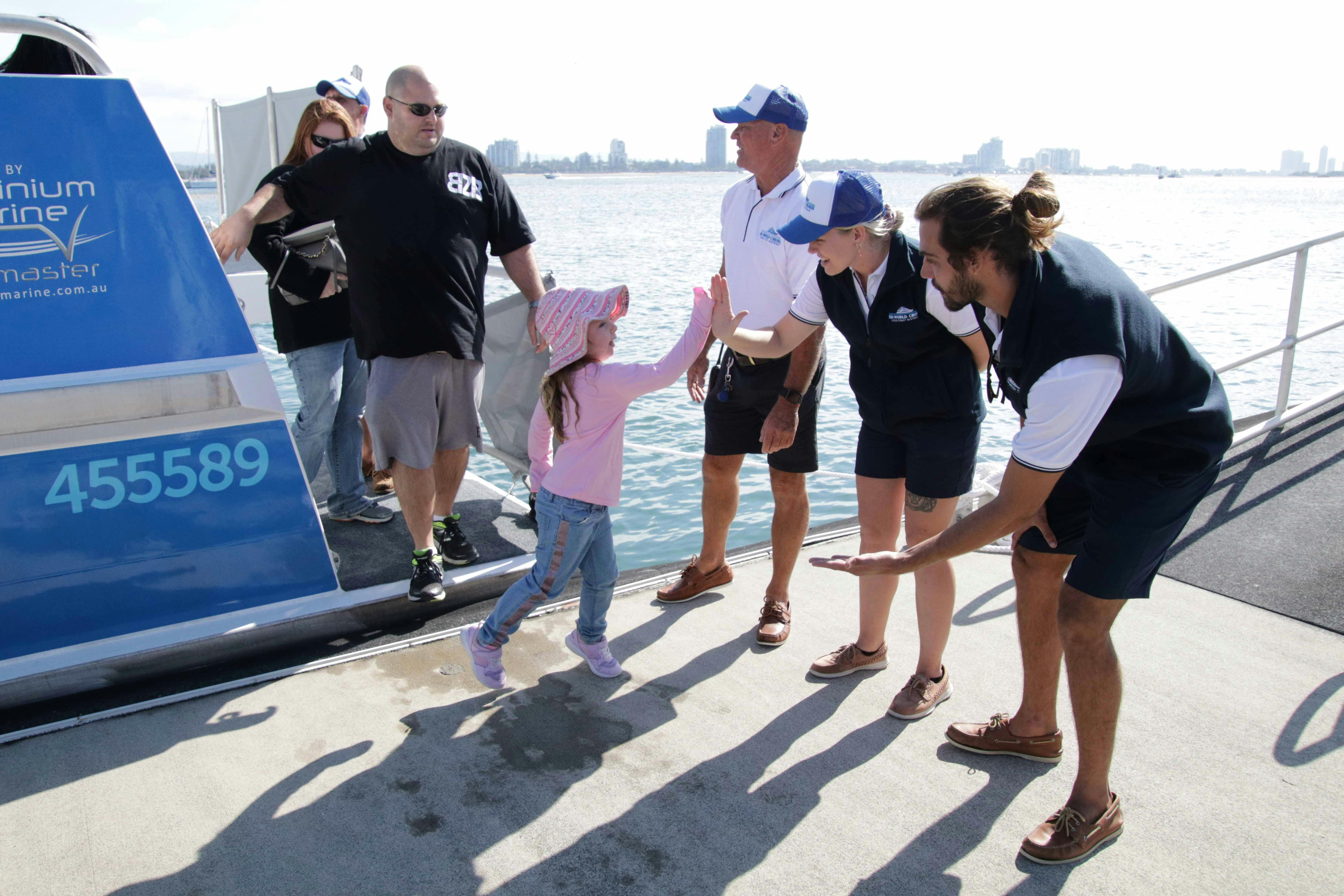 Boat crew high-fiving young girl
