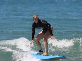 A surfer rides one of her first waves