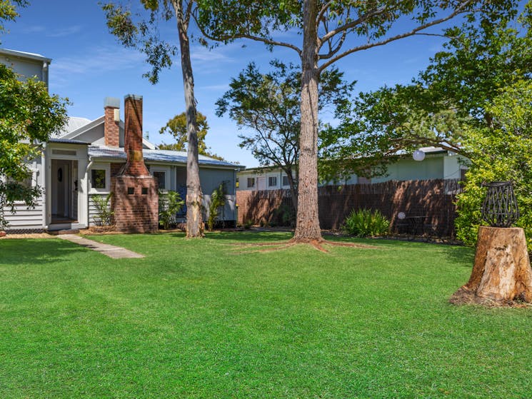 Grassy, flat backyard with gumtrees.